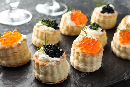 Preview: Tasty puff pastries with cream cheese, caviar and dill on table, closeup