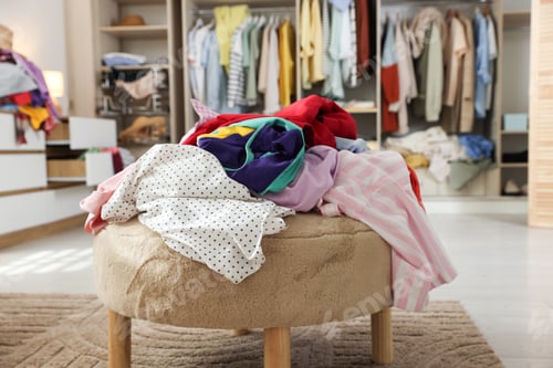 Preview: Many different messy clothes on stool in room, closeup