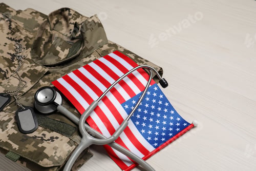 Preview: Stethoscope, USA flag, tags and military uniform on white wooden table