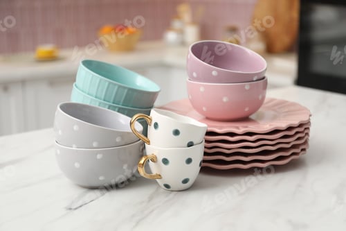 Preview: Different clean dishware on white table in kitchen