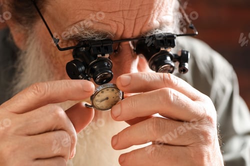 Preview: Senior man fixing mechanism of vintage wrist watch indoors, closeup