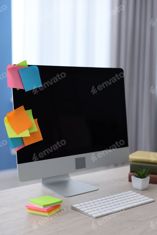 Preview: Computer with colorful sticky notes on light wooden table indoors. Multitasking, deadline and rush a