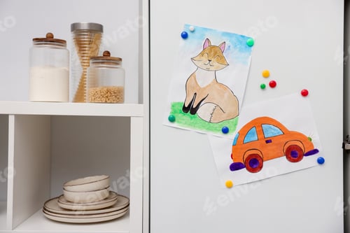 Preview: Child's drawings of car and cat on white cabinet indoors