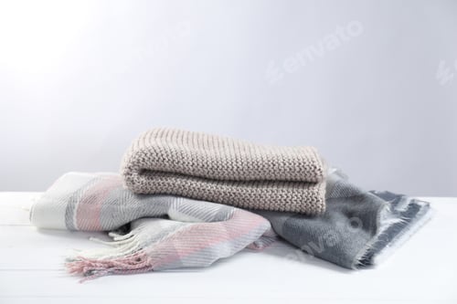 Preview: Stylish soft scarfs on white wooden table, space for text