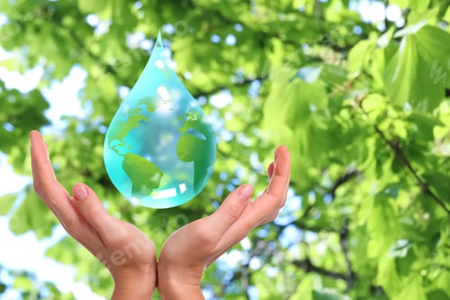 Preview: Save water concept. Drop with Earth inside falling into woman's hands against blurred green backgrou