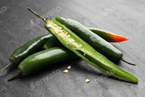 Preview: Fresh chili peppers on black textured table, closeup