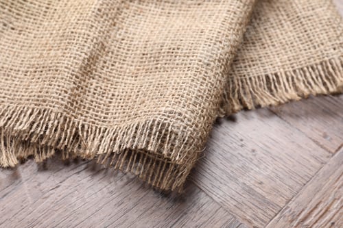 Preview: Natural burlap fabric on wooden table, closeup