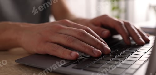 Preview: Man working on laptop at wooden desk, closeup