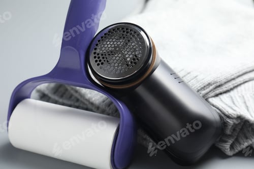 Preview: Lint roller, fabric shaver and sweater on light grey background, closeup