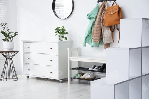 Preview: Hallway with stylish furniture, shoes and clothes, selective focus. Interior design