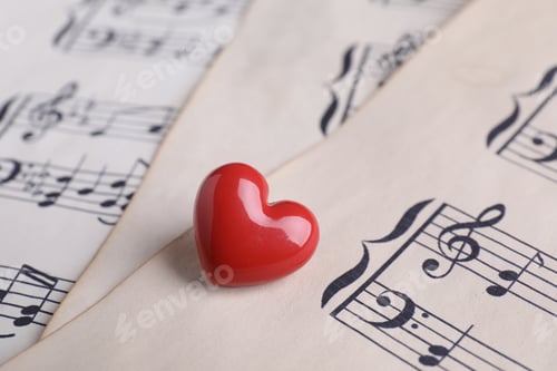 Preview: Heart figure on paper sheets with music notes, closeup