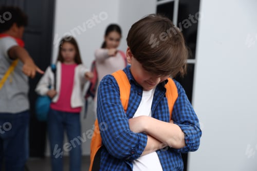 Preview: Boy getting bullied by his classmates in school hallway, selective focus
