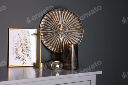 Preview: Beautiful vase and other decor on cabinet near black wall indoors, space for text