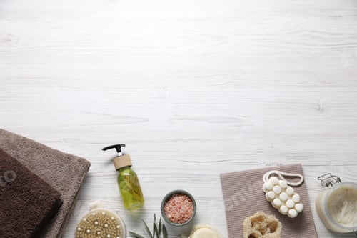 Preview: Clean towels and cosmetic products on light wooden table, flat lay. Space for text