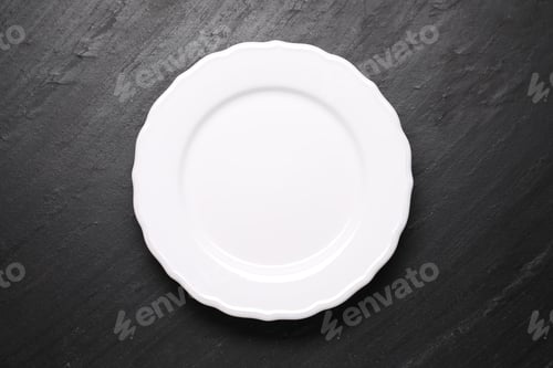 Preview: Empty plate on black table, top view