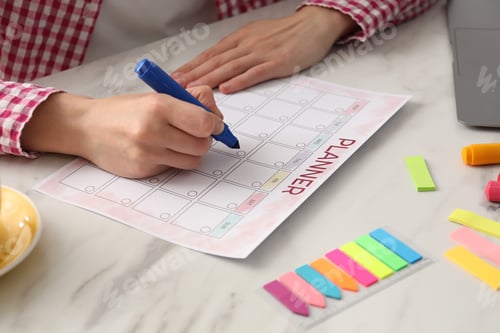 Preview: Woman using planner at white table, closeup