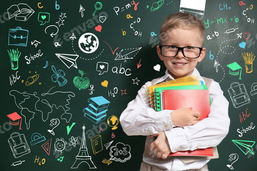 Preview: Cute little child in glasses near green chalkboard with drawings