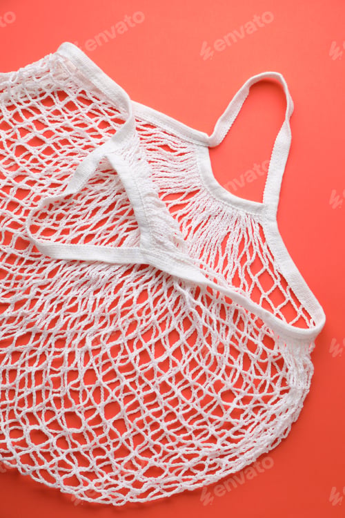 Preview: White string bag on red background, top view