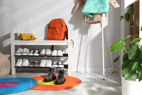 Preview: Shoe storage bench with different children's footwear, backpack and clothes indoors