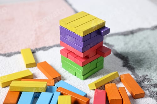 Preview: Colorful tower made of wooden blocks on floor, closeup