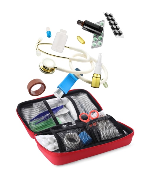 Preview: Drugs and medical supplies falling into first aid kit on white background