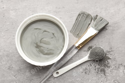 Preview: Mud therapy. Natural clay paste for facial and body care, brush and powder on grey table, flat lay