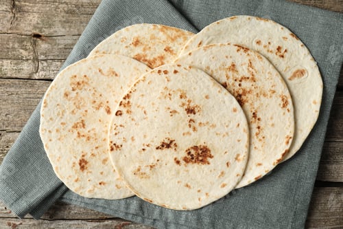 Vista previa: Sabrosas tortillas caseras en mesa de madera, vista desde arriba