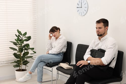 Preview: Man and woman waiting for job interview indoors