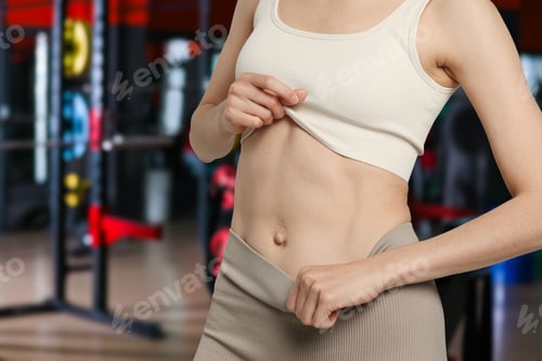 Preview: Athletic woman with flat belly in gym, closeup
