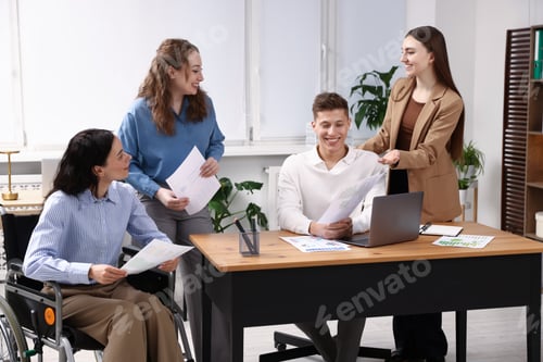 Preview: Inclusion. Woman in wheelchair and her colleagues working in office
