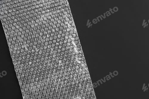 Preview: Transparent bubble wrap on black background, top view. Space for text