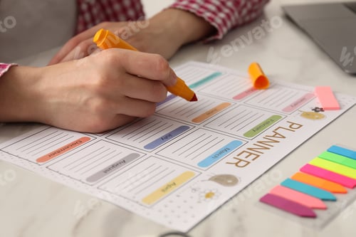 Preview: Woman using planner at white table, closeup