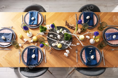 Preview: Easter celebration. Festive table setting with flowers and painted eggs indoors, flat lay