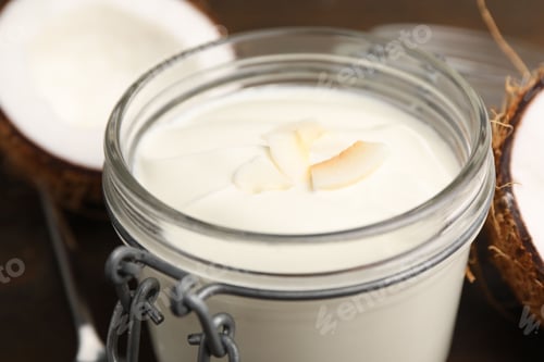 Preview: Delicious coconut yogurt in glass jar and fruits on wooden table, closeup