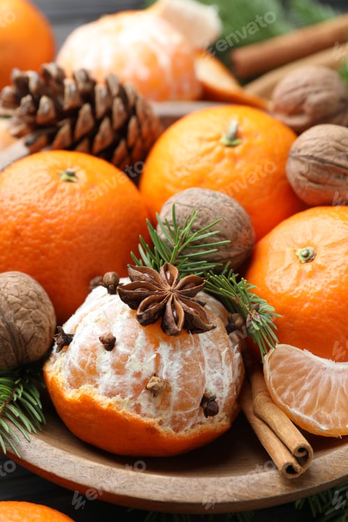 Preview: Ripe tangerines, spices, walnuts, fir tree branches and cone on table, closeup