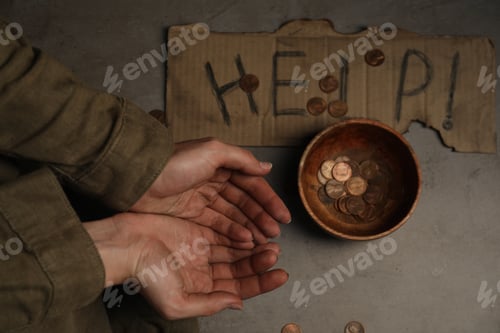 Preview: Poor homeless woman begging for money. Cardboard help sign and bowl with donations near her, top vie