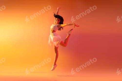Preview: Young woman performing hip-hop dance in neon light on color background