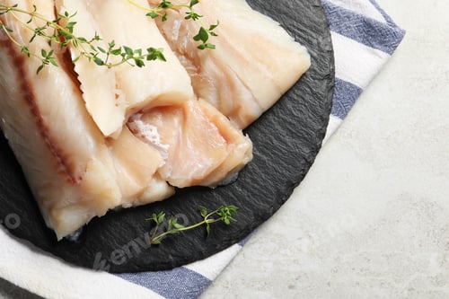 Preview: Pieces of raw cod fish and microgreens on light grey table, top view. Space for text