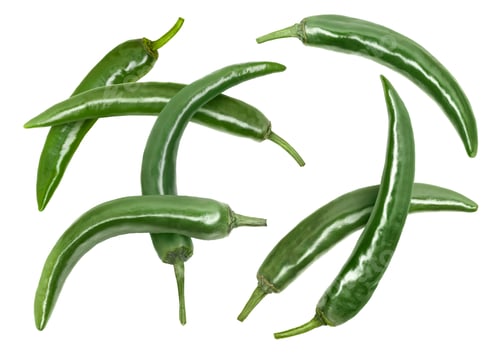 Preview: Green chili peppers flying in air on white background