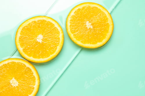 Preview: Orange slices in water on turquoise background, flat lay