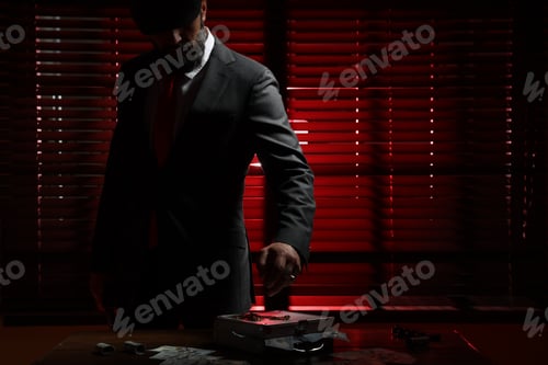 Preview: Mafia. Man with case of dollar banknotes and golden chain at table in dark room. Space for text