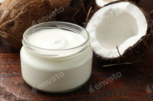 Preview: Tasty coconut yogurt in jar and fruits on wooden table, closeup