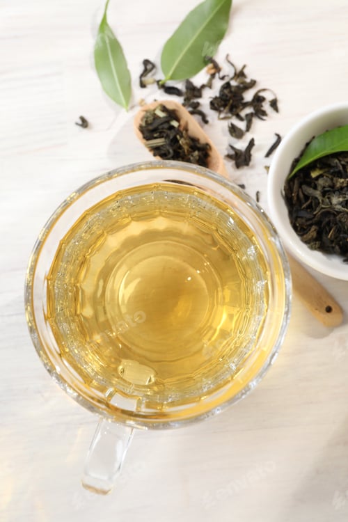 Preview: Refreshing green tea and dry leaves on white wooden table, flat lay