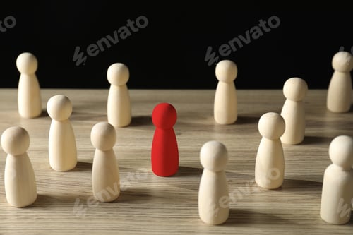 Preview: Dismissal. Red figure among wooden ones on table