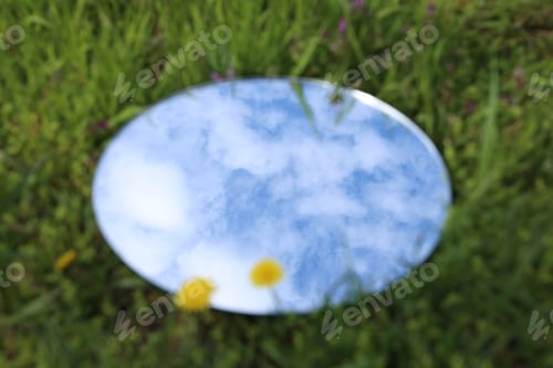 Preview: Blurred view of round mirror on green grass