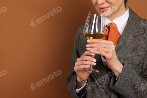 Preview: Professional sommelier tasting wine on brown background, closeup. Space for text