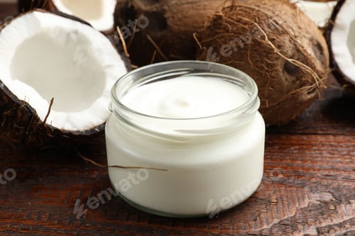 Preview: Tasty coconut yogurt in jar and fruits on wooden table, closeup