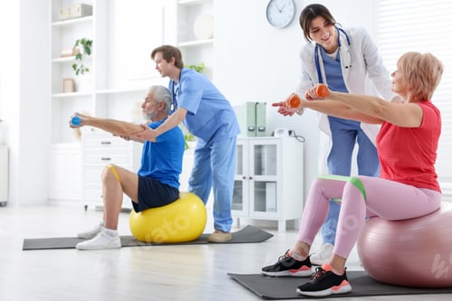 Preview: Senior woman and man training with dumbbells under physiotherapists supervision indoors