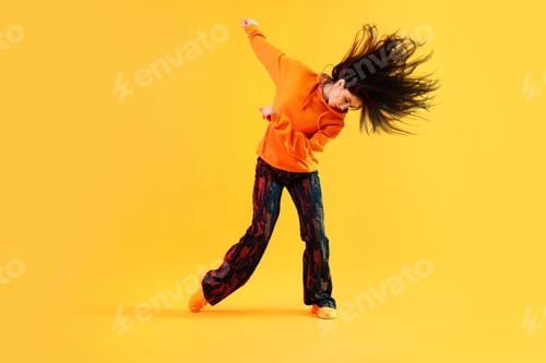 Preview: Young woman performing hip-hop dance on color background