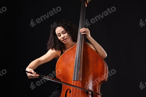 Preview: Woman playing double bass on black background